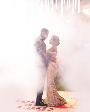 Romantic couple dancing in a misty outdoor setting during their wedding celebration.