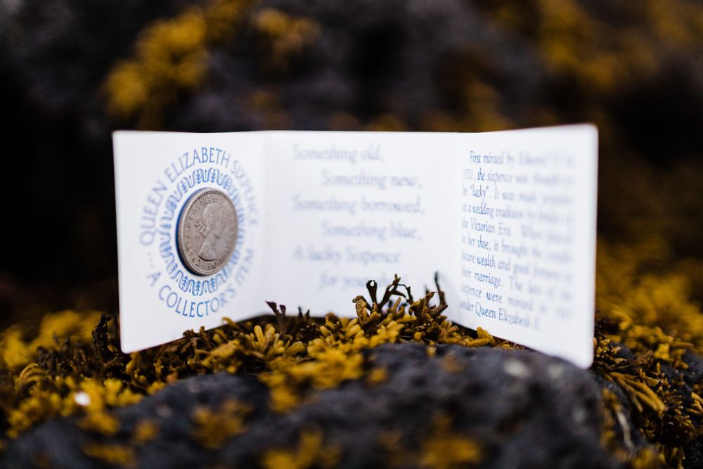 Wedding invitation card placed on mossy surface with vintage design elements.