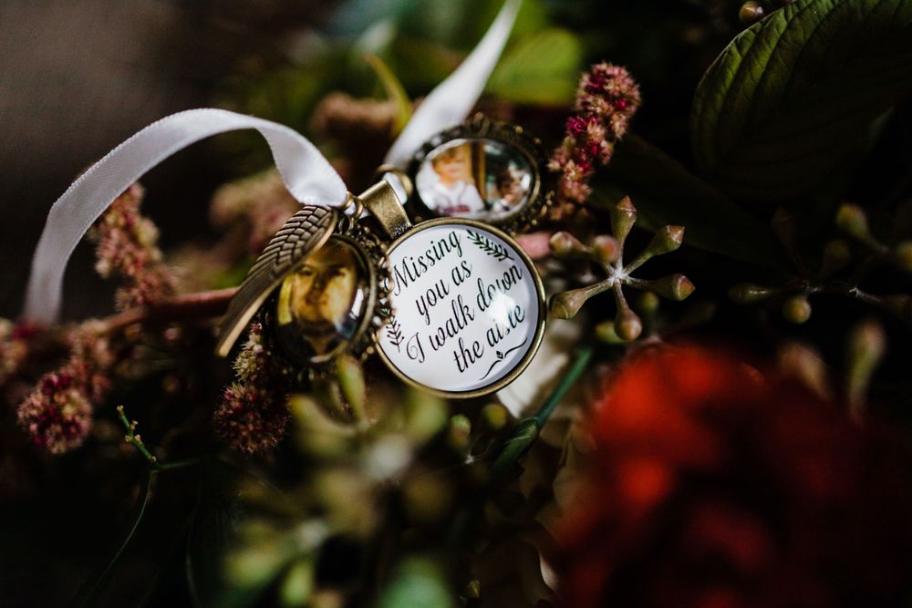 Decorative wedding ring detail shot with floral elements in soft focus.