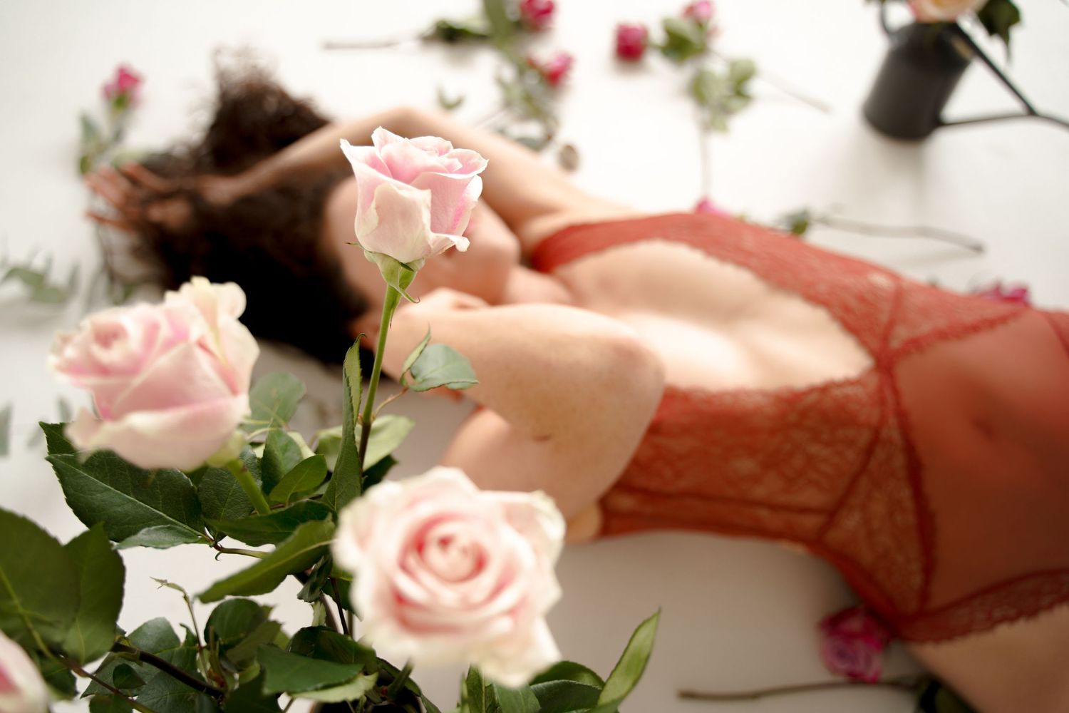 Delicate pink roses in soft focus with hands gently touching petals.