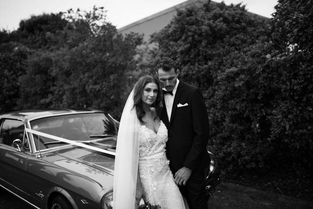 Classic car parked on scenic road for wedding day photos.