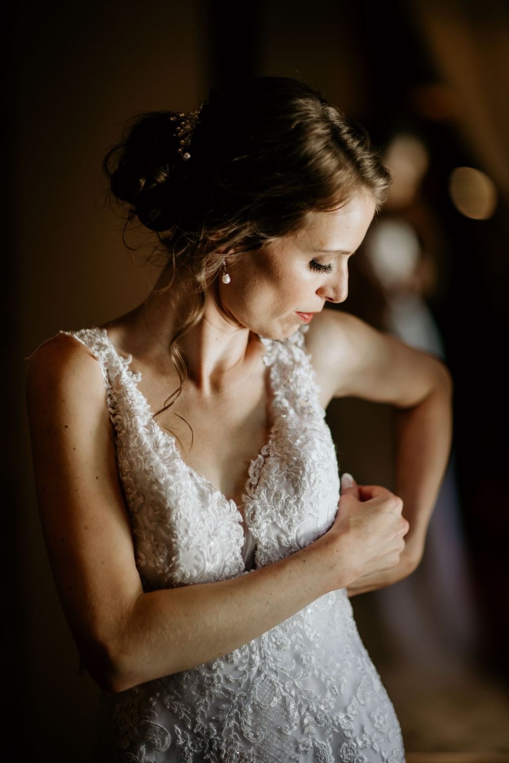 Artistic portrait of bride in lace dress with romantic lighting.