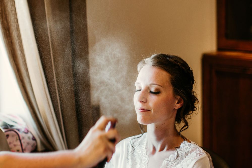 Final touches of wedding day preparation with delicate white lace dress.