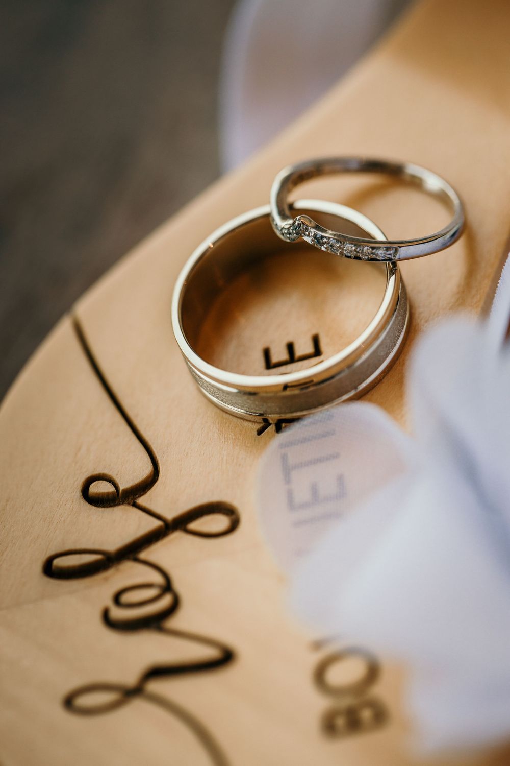 Wedding rings photographed on paper with calligraphy details.