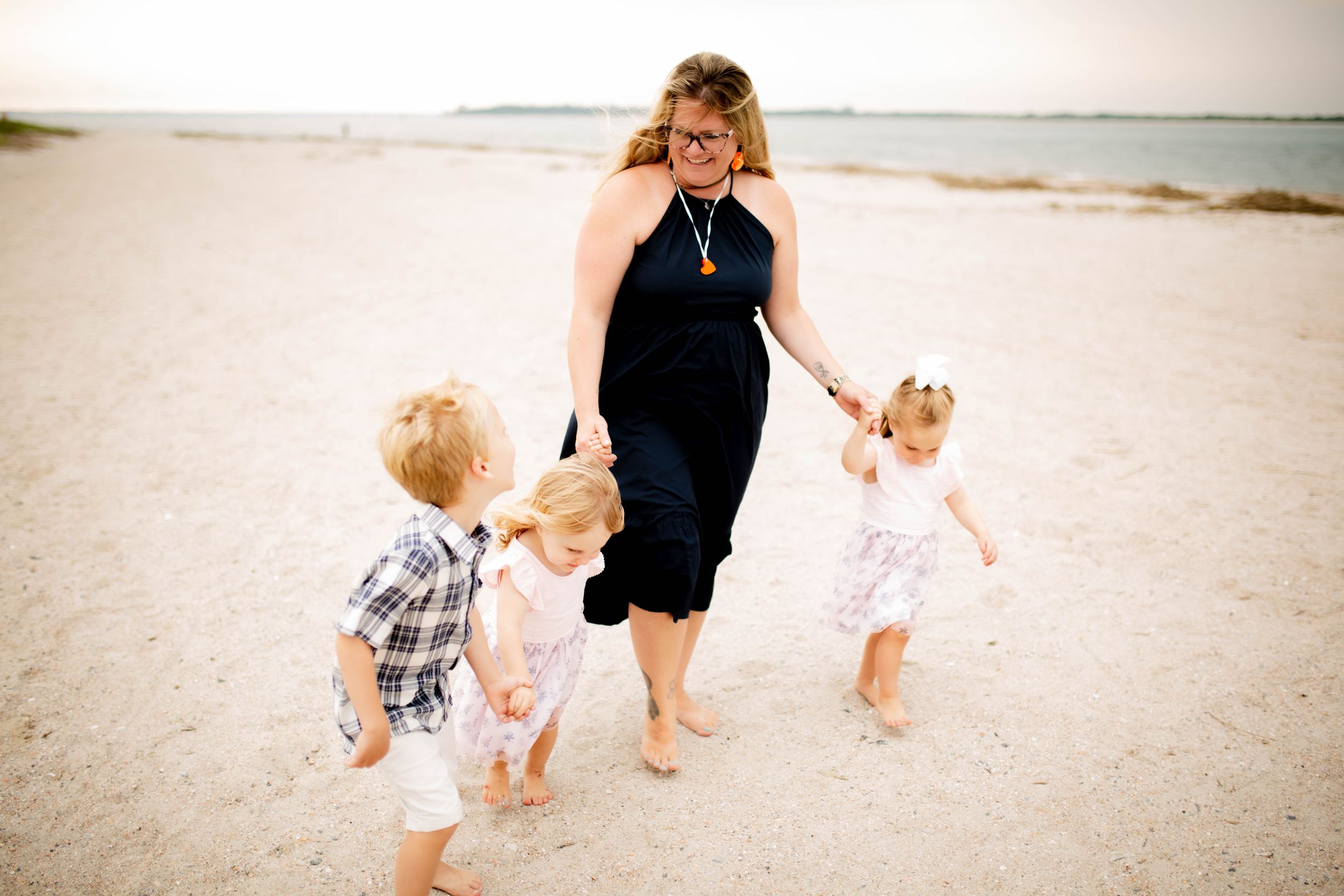Joyful beach scene with walking and playing together in the sand at sunset.