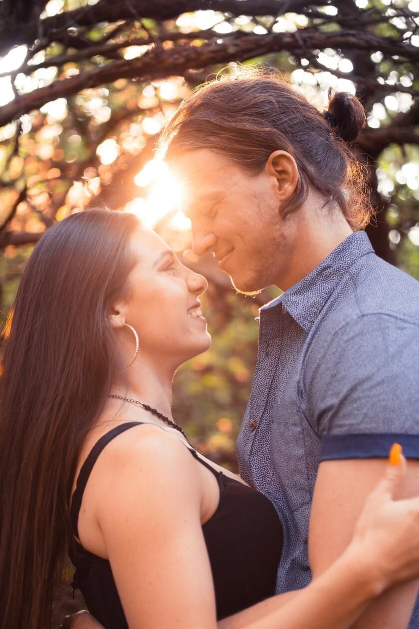 Romantic photo of couple in forest with sunset background