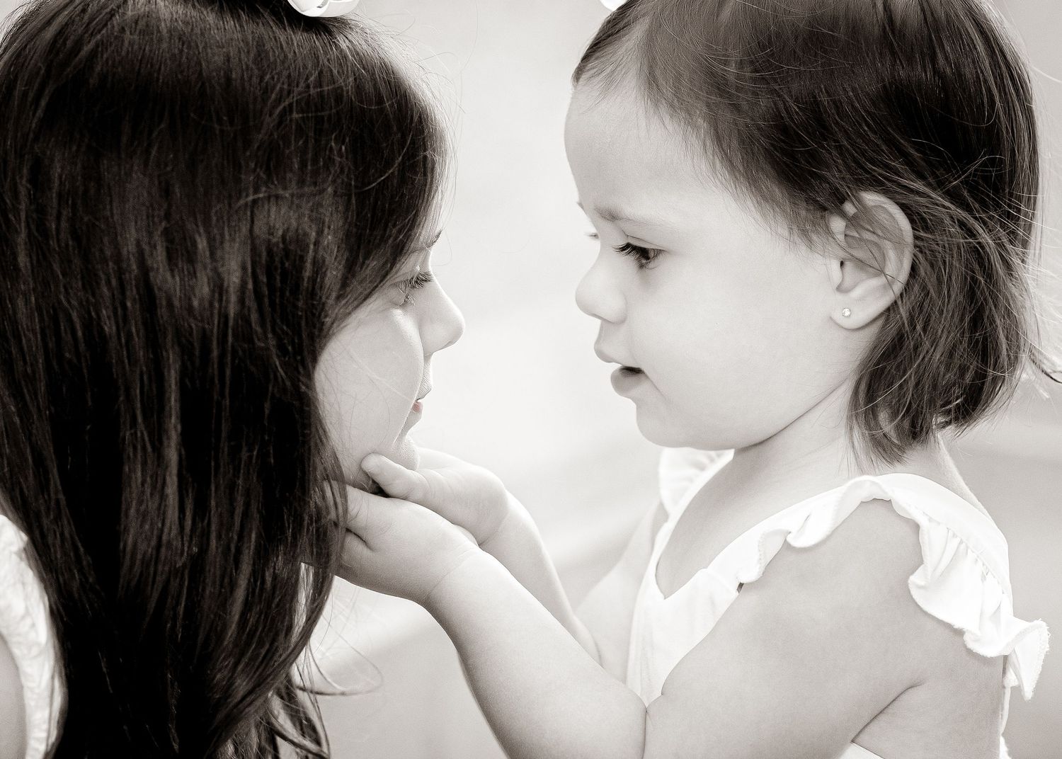 Mother and daughter share intimate black and white portrait with touching faces.