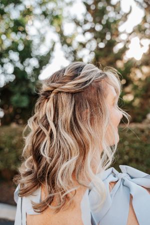 Close-up of wavy blonde hair styled with braids in natural lighting.