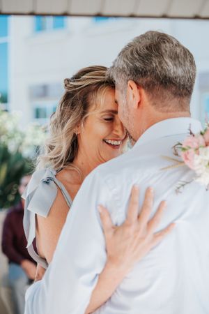 Intimate wedding moment captured under a white gazebo with natural lighting.