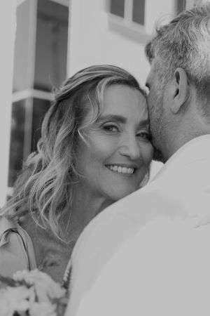 Black and white portrait of couple sharing tender moment outdoors.