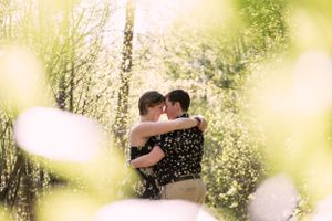 A lesbian couple hugging intimately in the woods