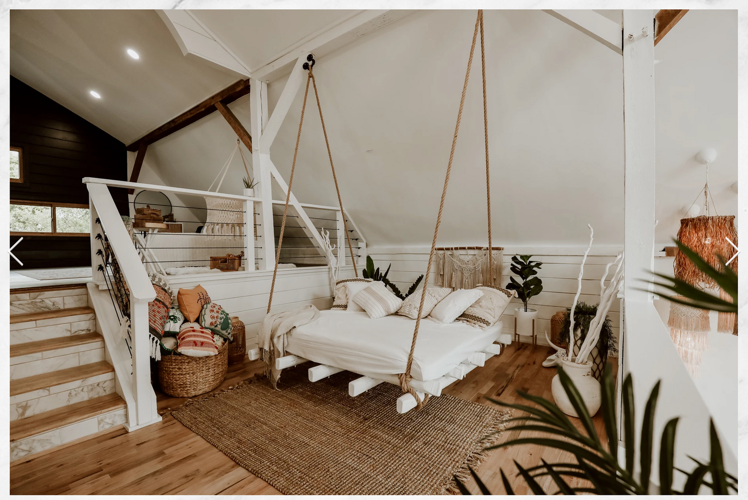 Light and airy white loft space with high ceilings, exposed brick walls and hardwood flooring.