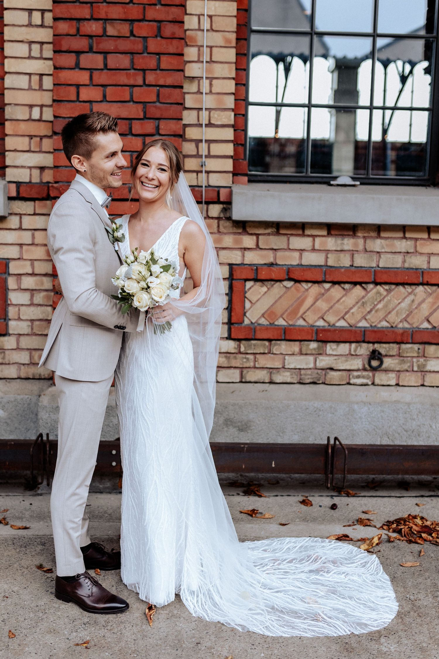 Classic wedding portrait of couple in front of vintage brick building.