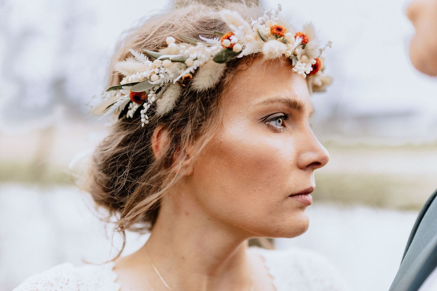 Delicate floral crown adorns figure in soft natural light for romantic bridal portrait.