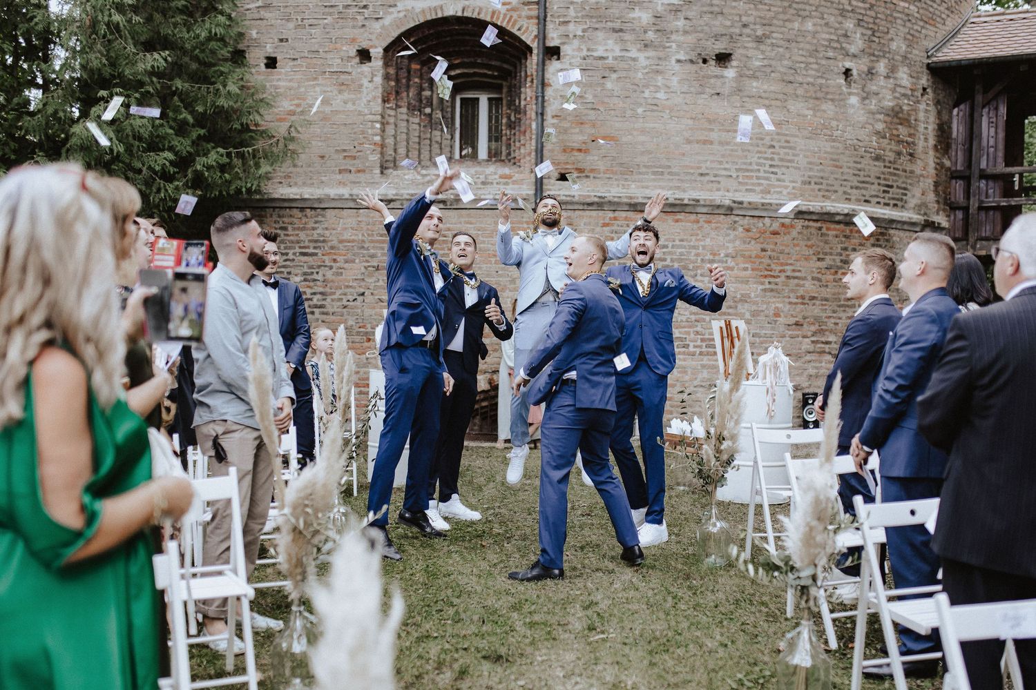 Guests celebrate during outdoor wedding ceremony with joyful dancing in courtyard.