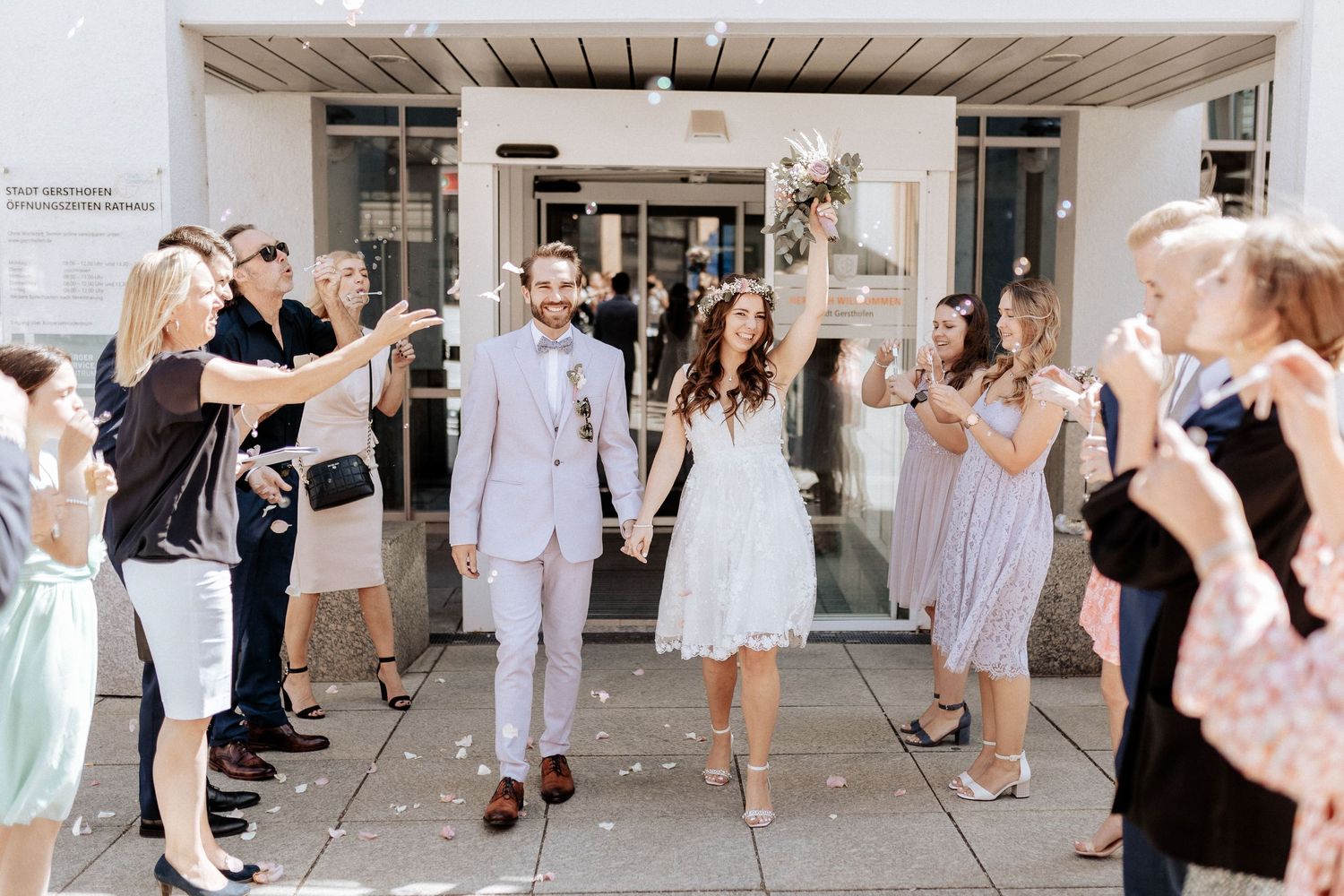 Wedding party exit with guests lined up outside throwing confetti at the celebrating couple.