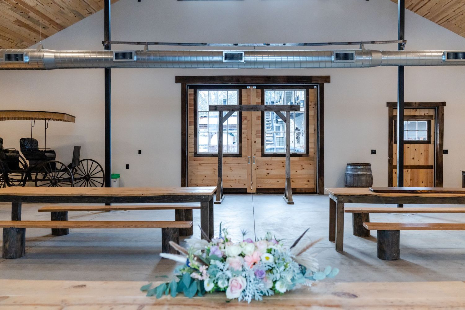 floral table piece and a view of the barn hall