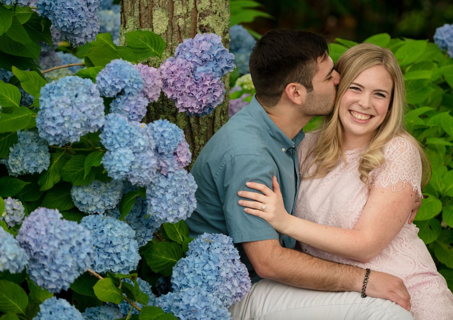 Romantic moment captured among blooming blue hydrangea flowers in a garden setting.