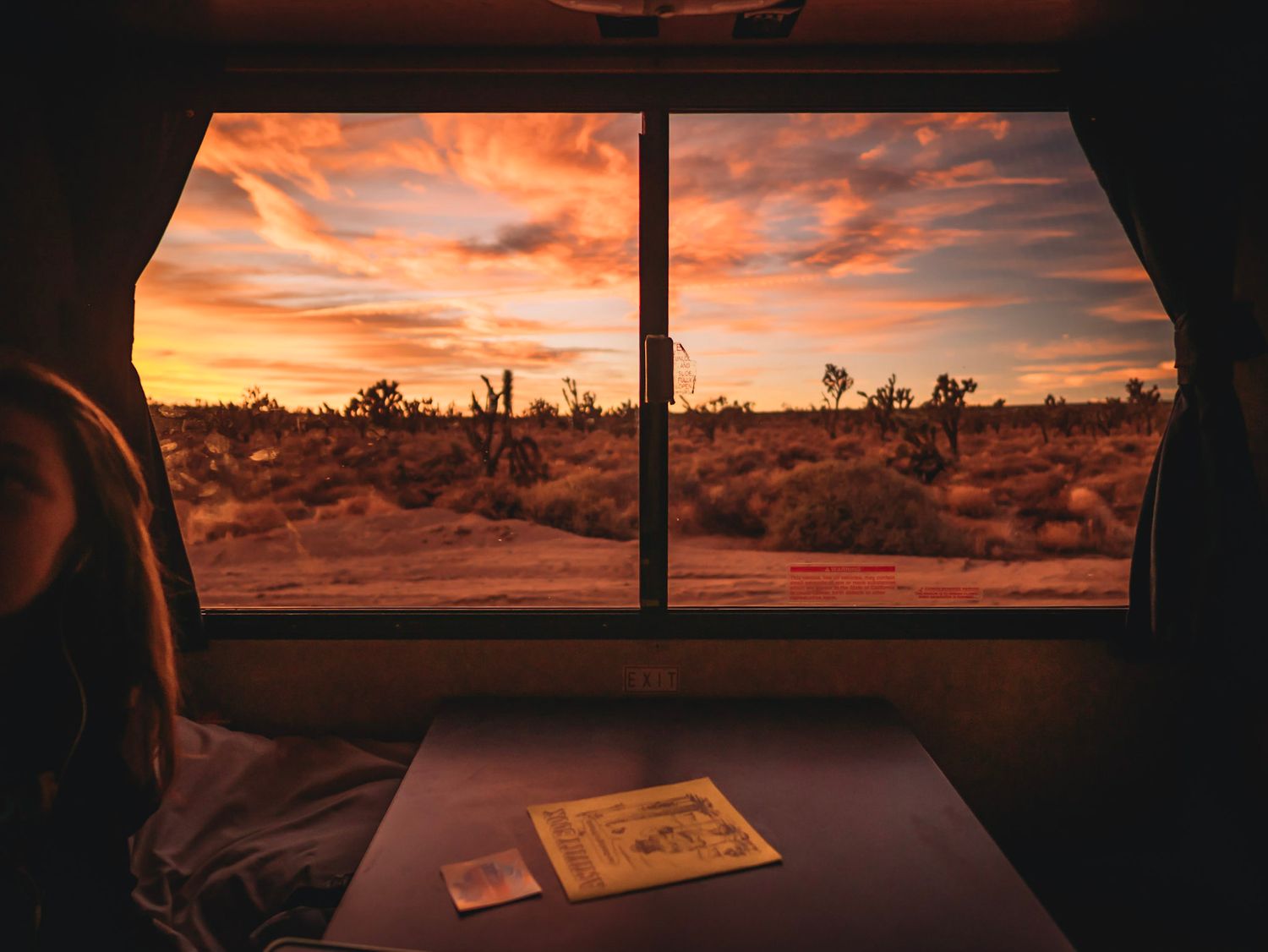 A child in an AR in the Mojave desert. The sun is setting and glaring through the large window. Taken from within the RV
