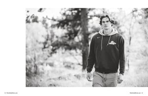 Black and white portrait of person in casual wear walking outdoors.