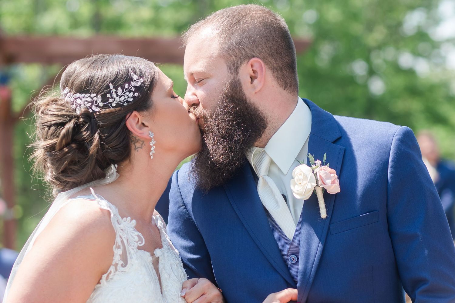 Wedding couple shares intimate moments in formal attire against a natural outdoor backdrop.