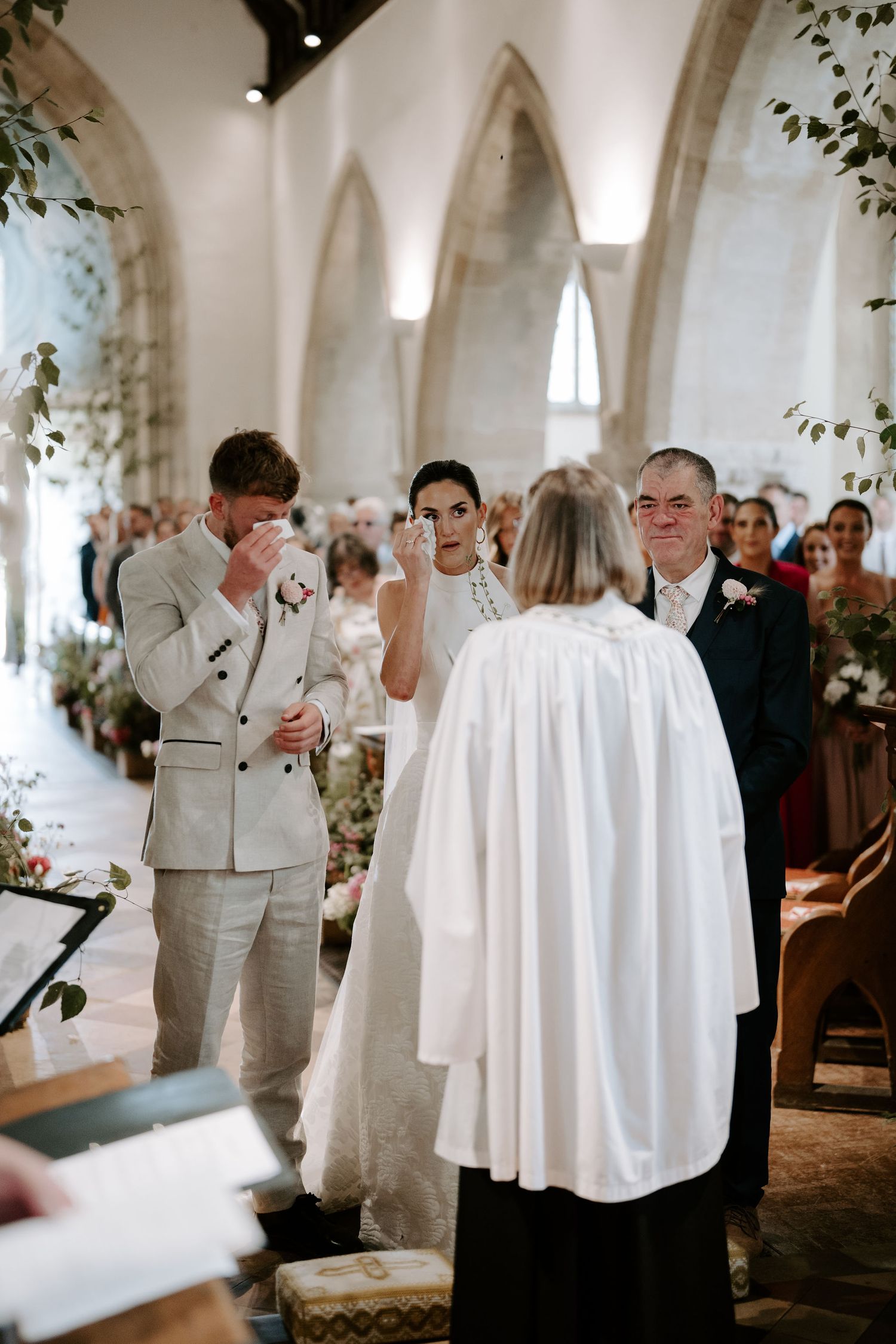 bride and groom wiping their tears away at the alter  at st Nicholas church in Oxfordshire