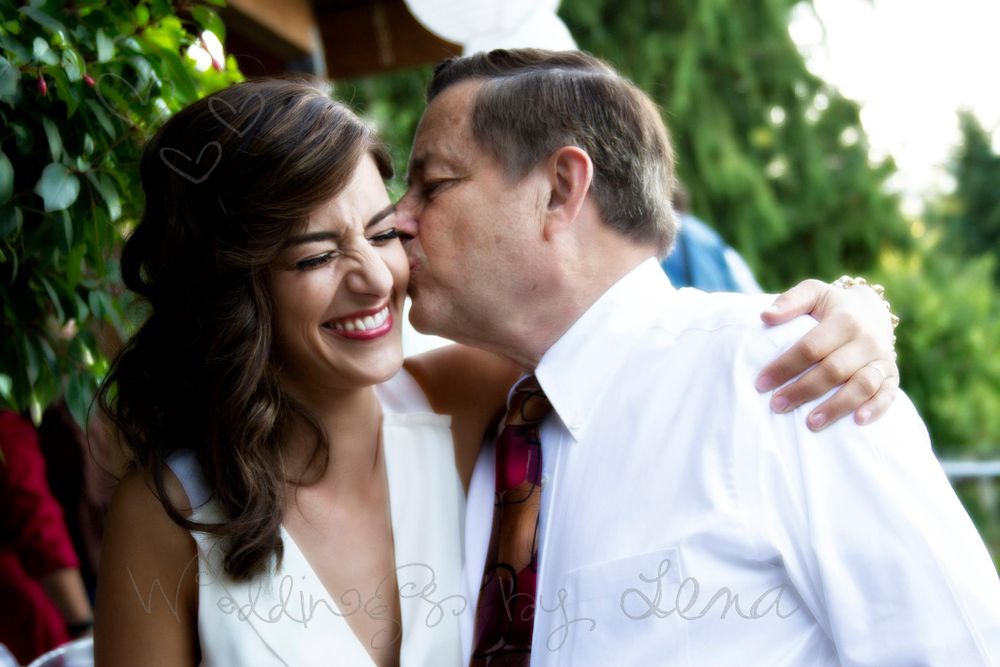 Romantic couple embracing outdoors among green foliage.