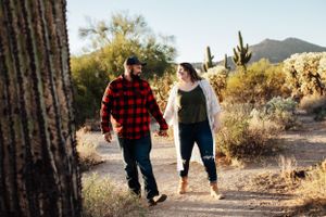 Family walking together through a desert landscape with saguaro cacti at sunset.