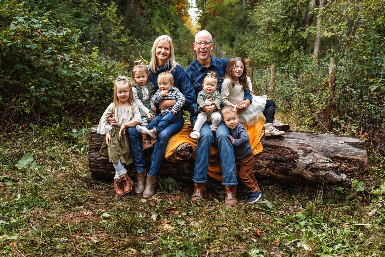 Family sitting together on fallen log in autumn forest setting for outdoor portrait.
Janesville, WI
Brodhead, WI