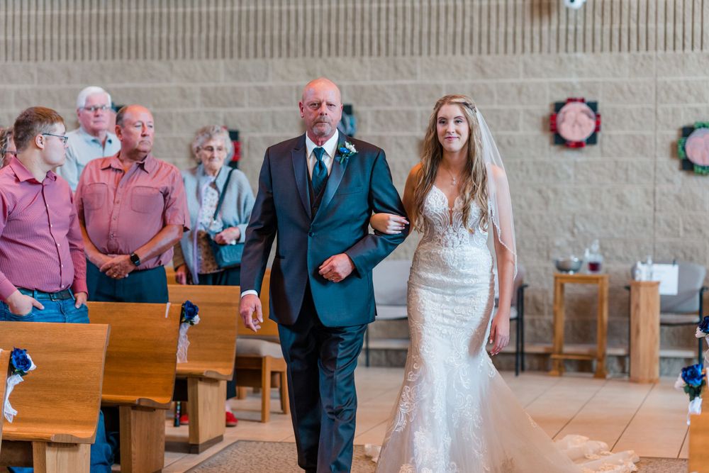 A moving moment during a church wedding ceremony with pews in the background.