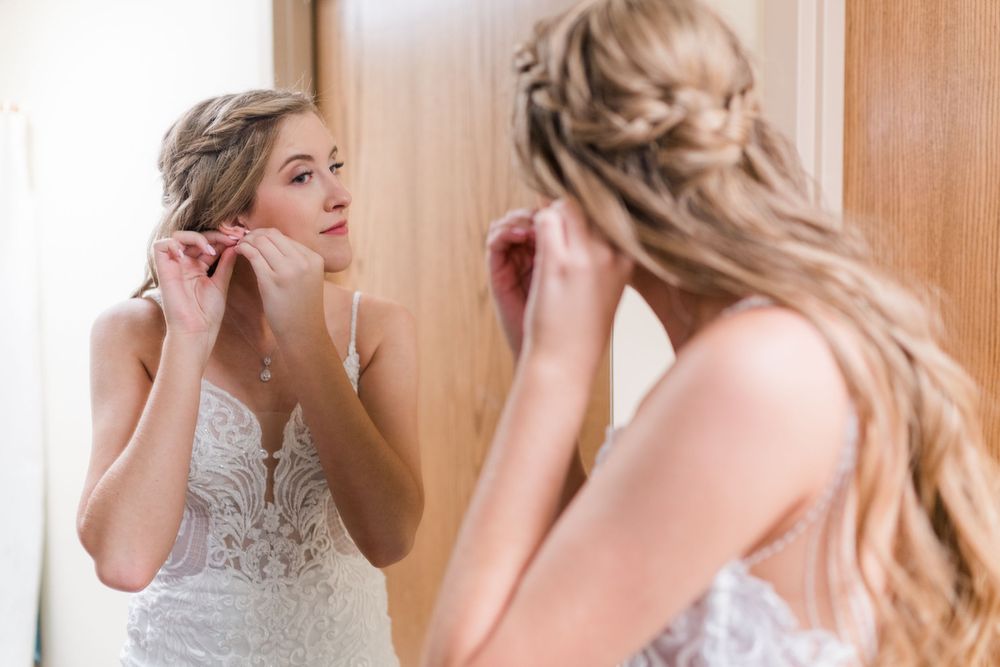 A close up image of someone getting ready on their wedding day in a white lace dress.