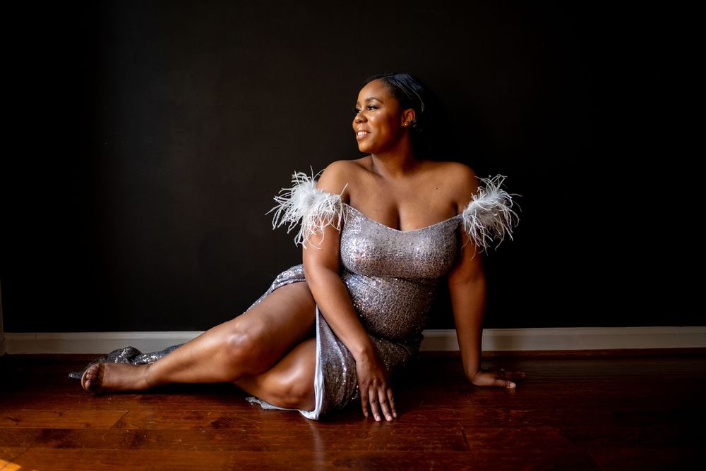 black woman celebrating her birthday on green couch at natural light studio