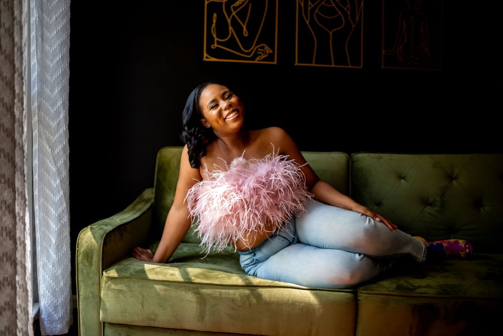black woman celebrating her birthday on green couch at natural light studio