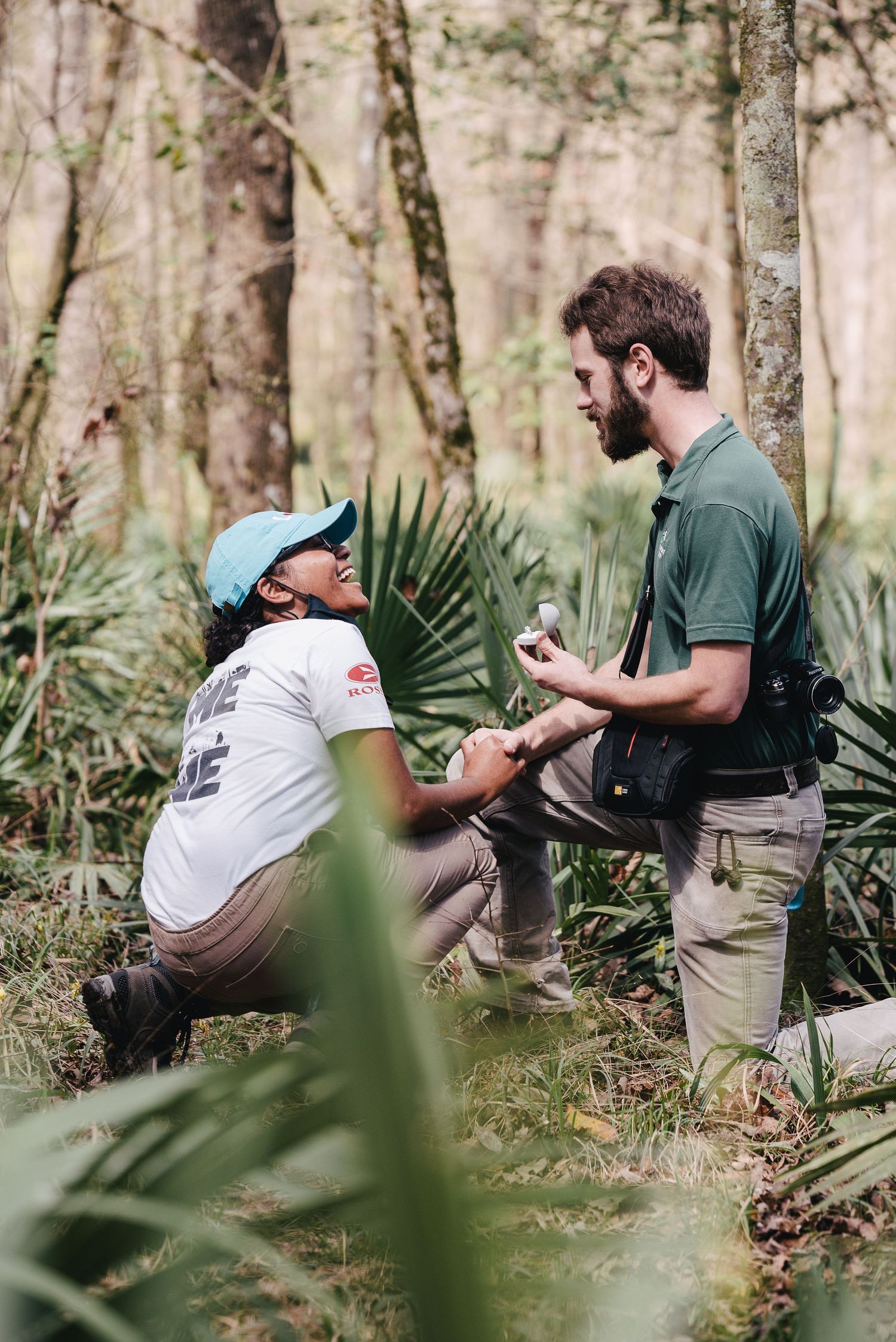 A proposal captured in a natural woodland setting surrounded by palm fronds.