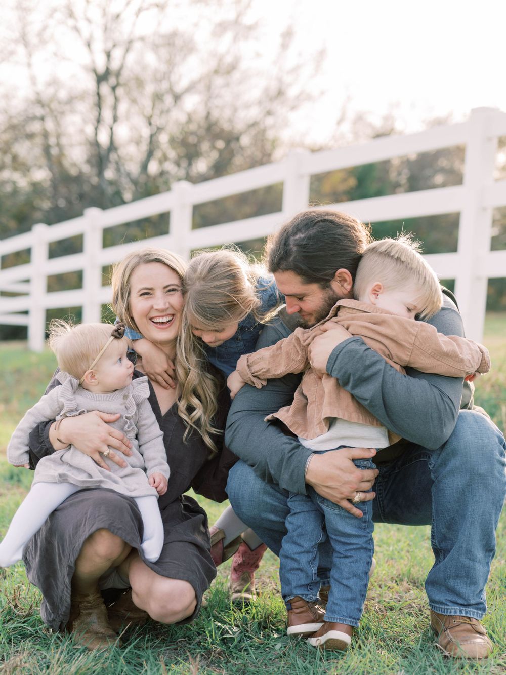 outdoor family session of. a mom and dad hugging their two daughters and son