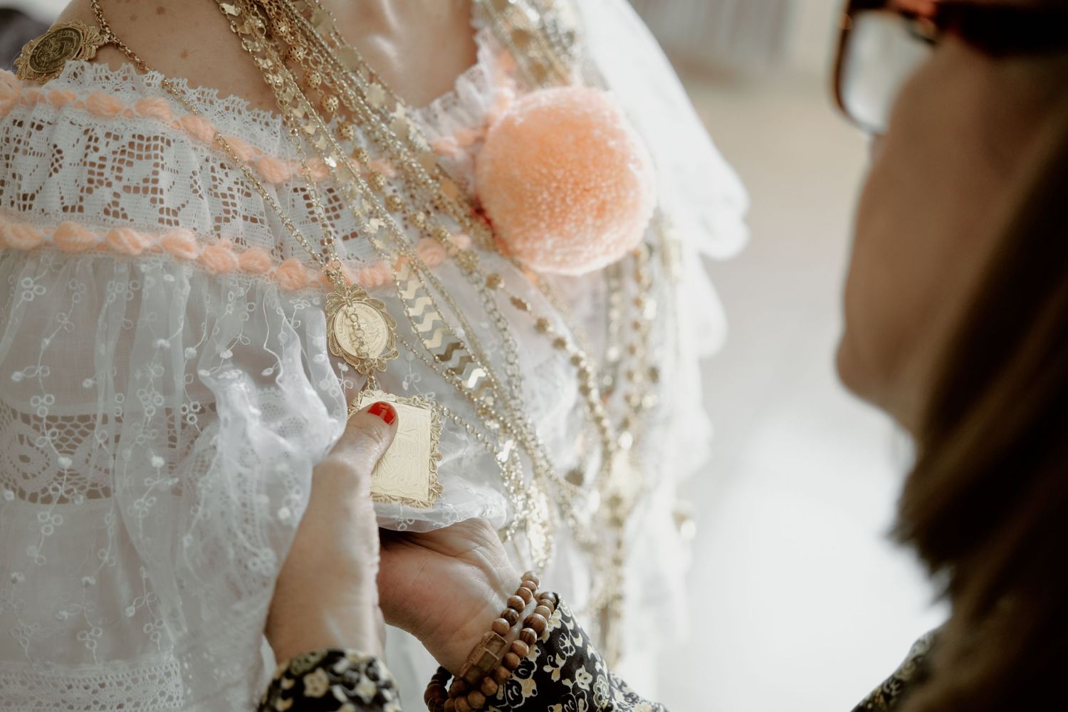 Close-up detail of intricate beading and lace on a white wedding dress.