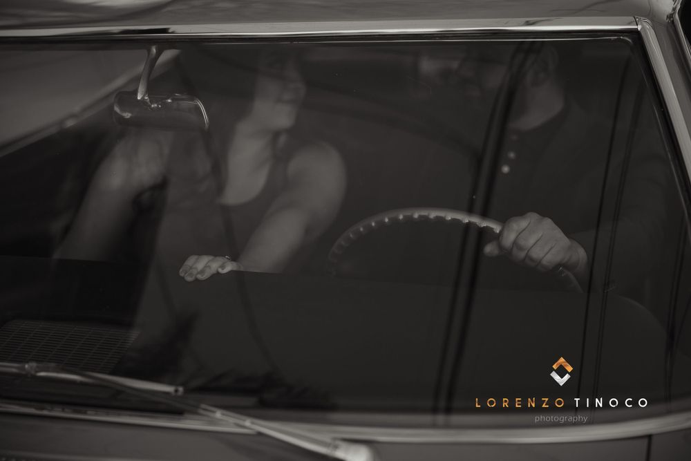 Artistic silhouette shot of couple inside classic car.