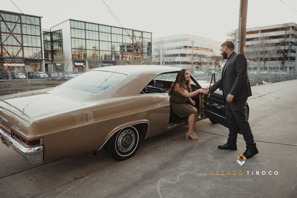 Couple posing with vintage brown Chevrolet during urban photoshoot.
