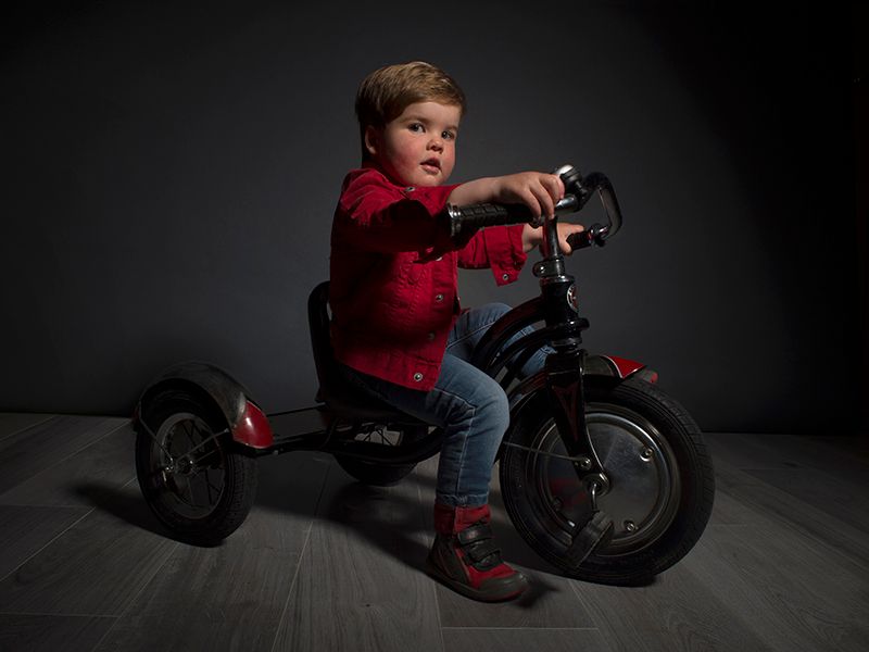 Toddler boy on bike in studio photography, High Wycombe. Photographer Abigail's Studio