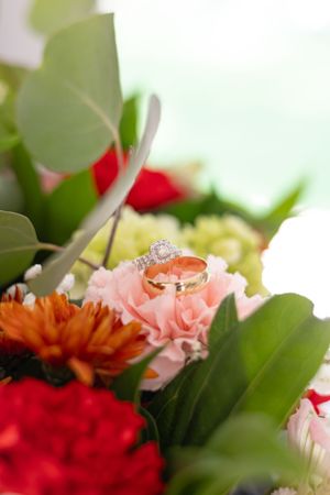 Wedding bride and grooms rings sitting on their wedding day flowers.