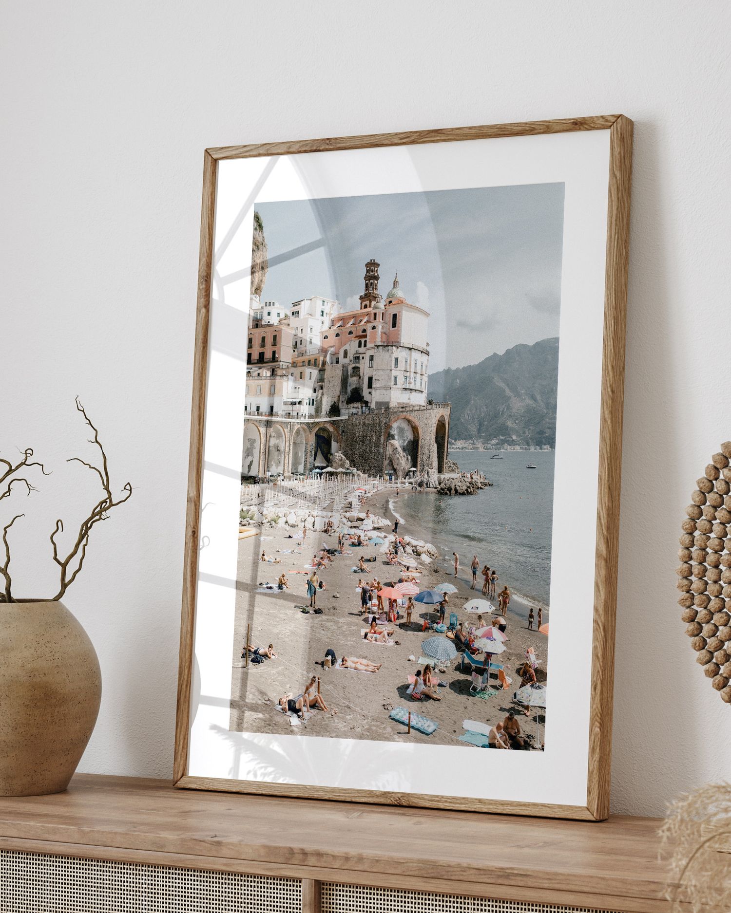 Framed photograph of Atrani beach on Amalfi Coast with historic architecture and beachgoers.