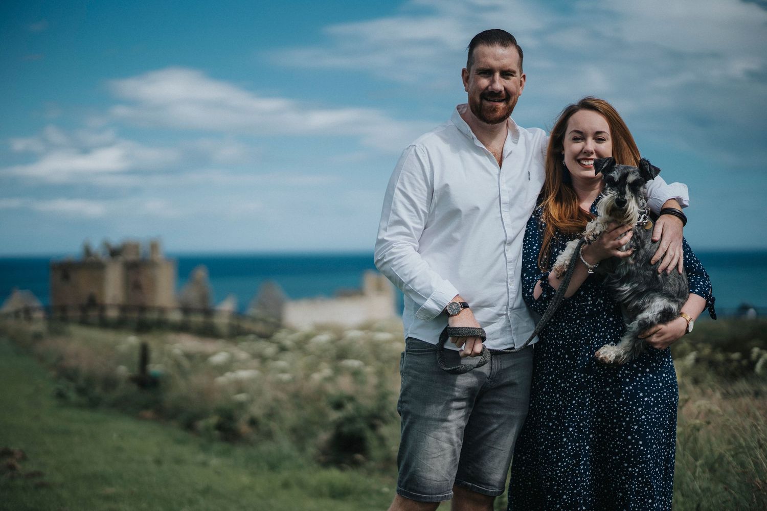 a couple posing with their dog
