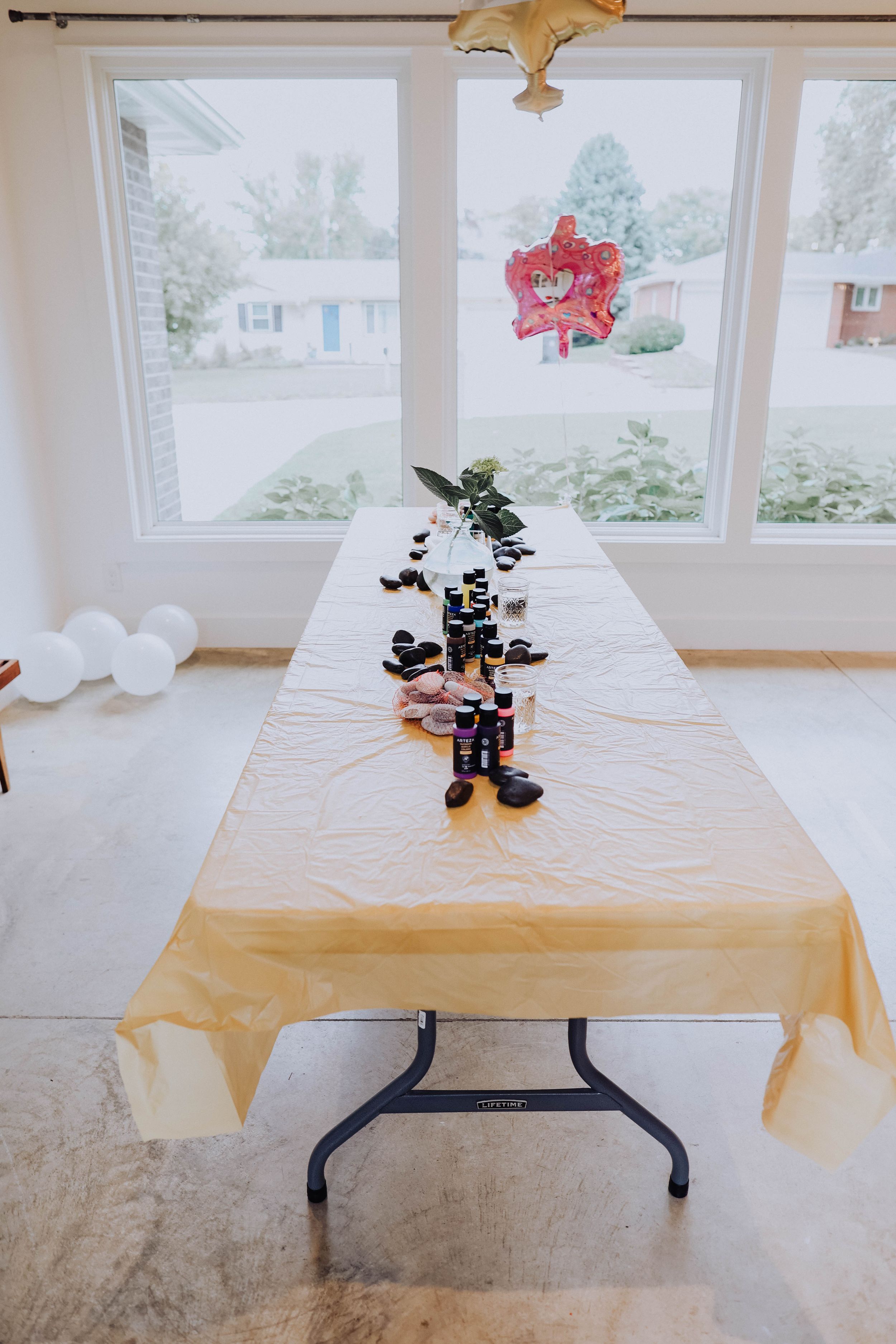Studio table setup with toys and decorations on gold tablecloth.