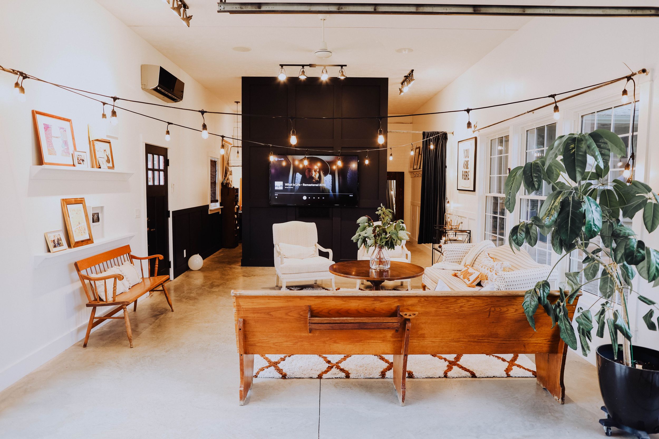 Modern studio space with wooden furniture, track lighting, and minimalist decor.