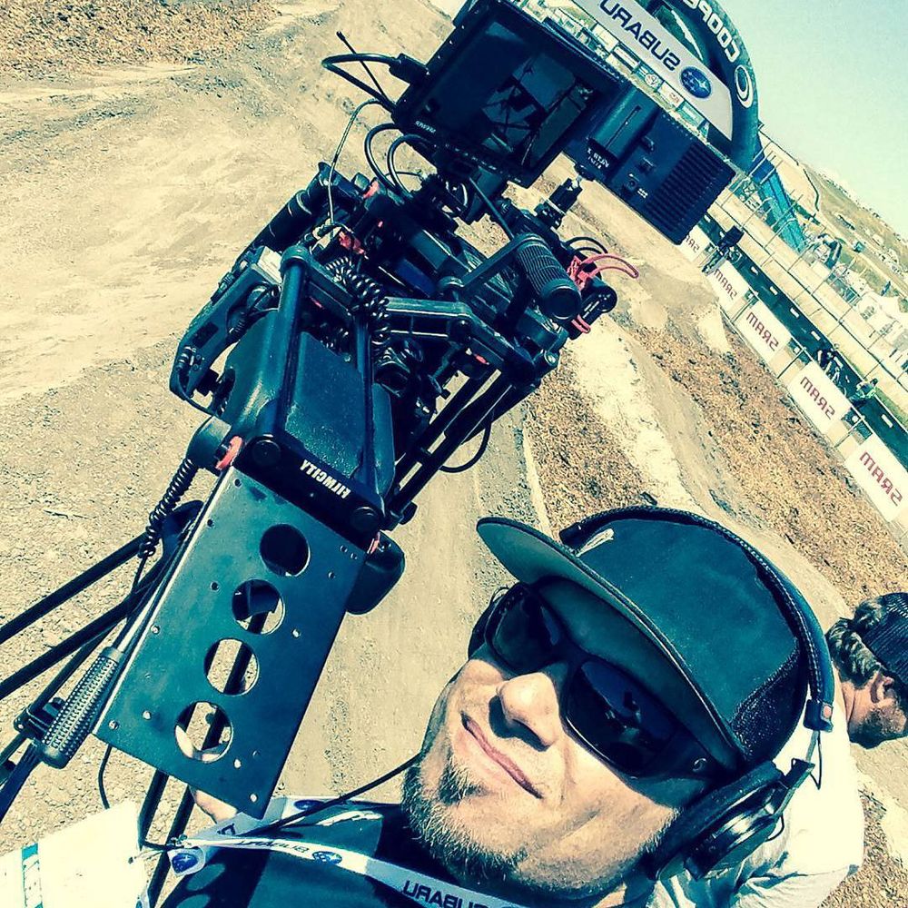 Close-up shot of professional camera equipment mounted on a rig in a desert setting.