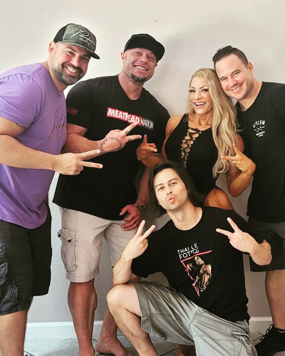 Group photo of content creators and crew members posing together against a light background.