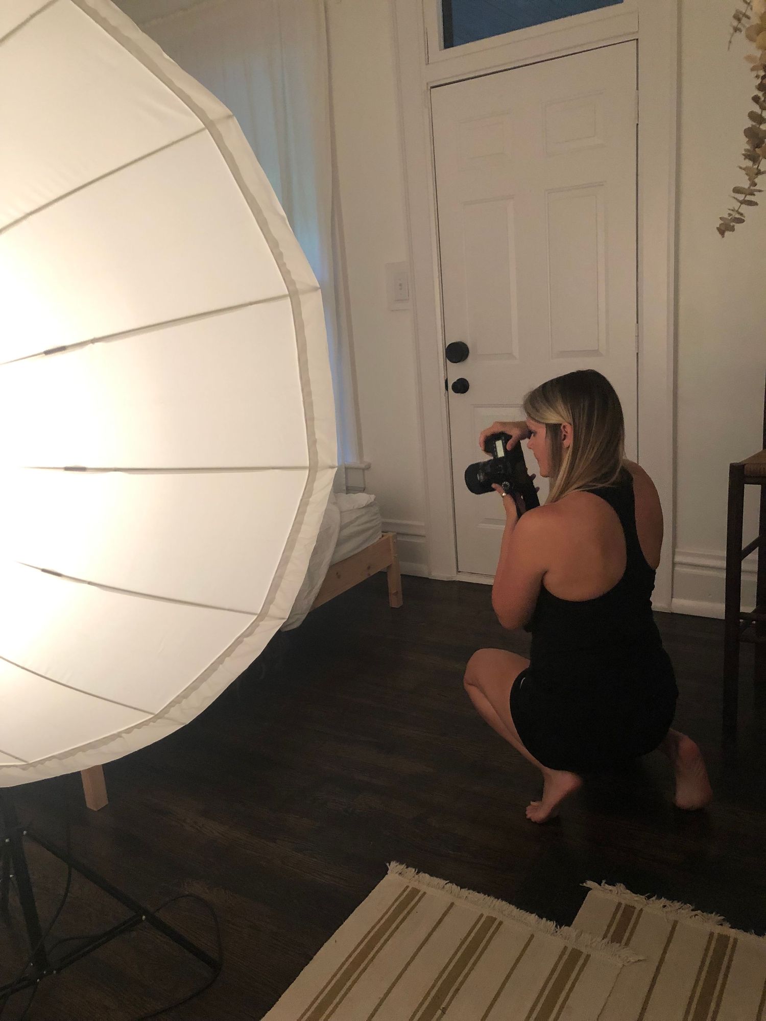 Studio photography session with lighting equipment and hardwood flooring.