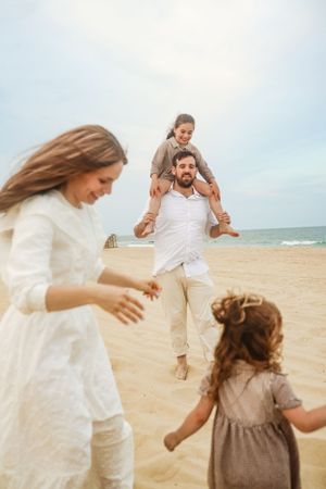 Family running around the beach naturally posed by a photographer in Lakewood, NJ