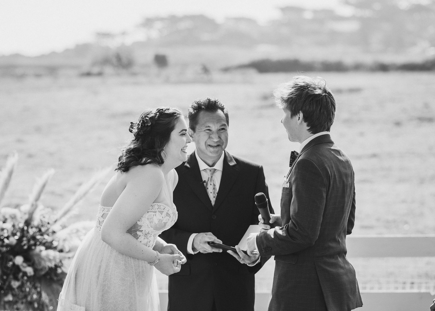 A joyful outdoor wedding ceremony moment captured in black and white photography.