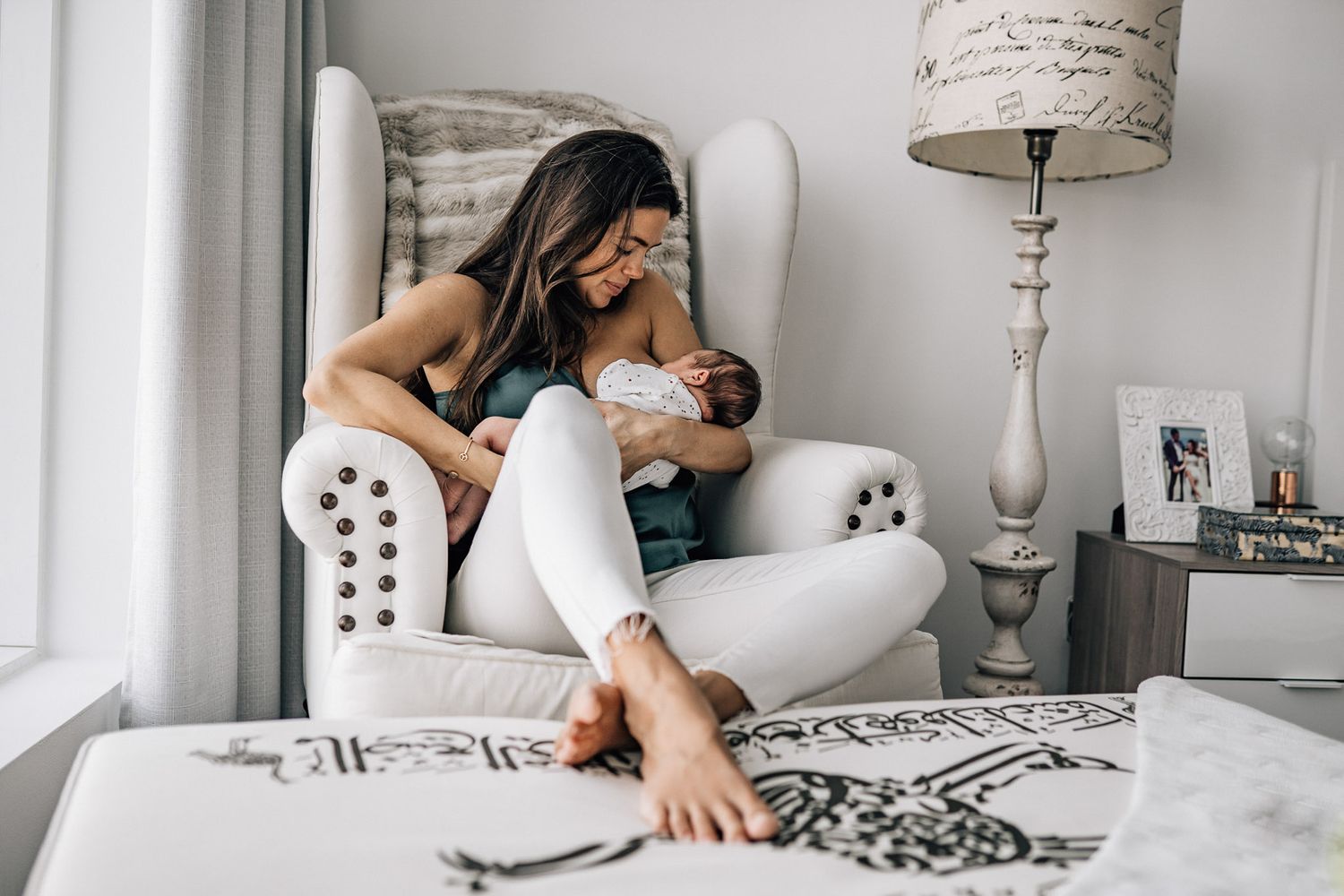 mom feeding her baby during the lifestyle newborn photography session in dubai